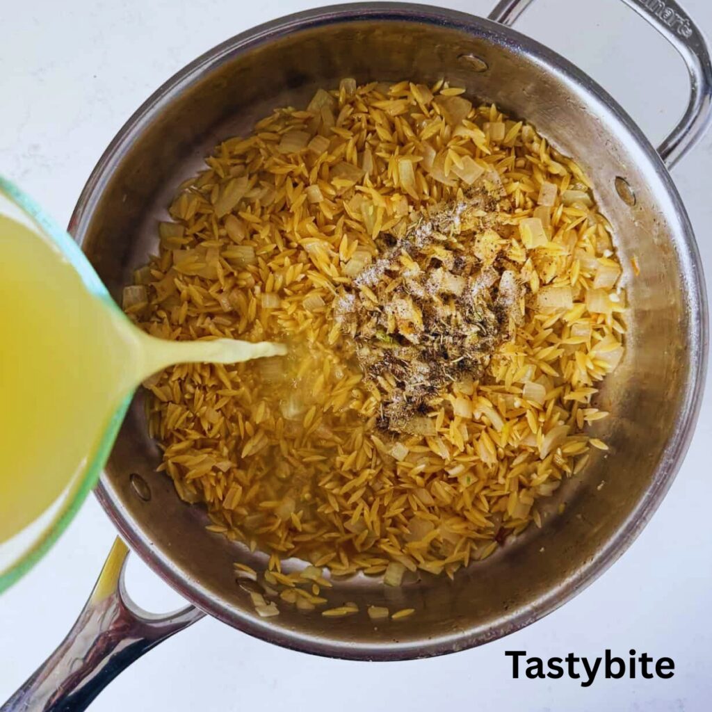 Orzo and broth added to skillet