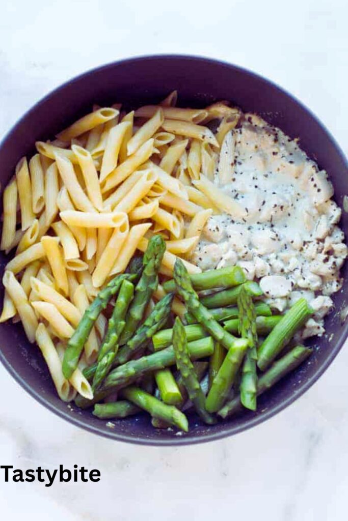 Adding broth, chicken, and asparagus